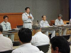参加されている住民の方々の前で市長が自席で立って、まちづくりについて説明している写真