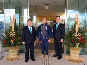 イーストピアみやこ正面玄関に飾られた立派な門松の間に並んでいる左から市長、せきぐち緑化様、職員の3名での写真
