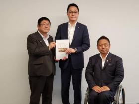 市長とスーツ姿の関係者の男性と一緒に要望書を持ち車いすに乗った男性と並んで記念撮影をしている写真