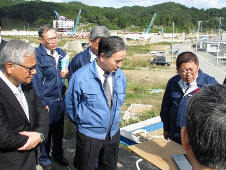 平野達男復興大臣と黄川田徹副大臣、関係者が宮古市を視察し、市長が説明する様子の写真