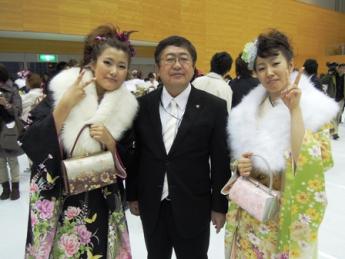 黒い振袖と黄緑色の振袖をきた女性の間に市長が立ち記念撮影している写真