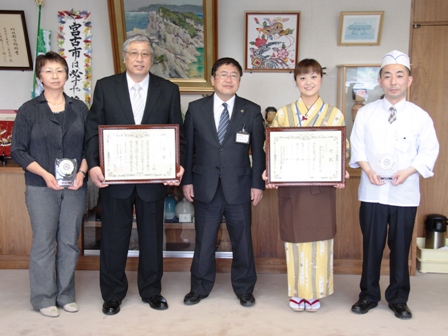 額縁に入った賞状を手に持つ関係者と市長が横に並んでいる写真