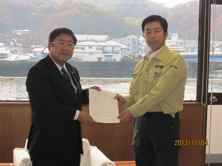 市長と牧原秀樹環境大臣政務官が書面を一緒に持ち記念撮影を行っている写真