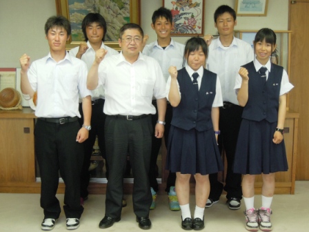 制服を着た男子生徒4名と女子生徒2名が市長とガッツポーズをし記念撮影している写真