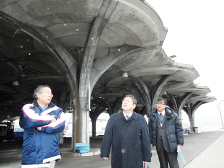 北海道奥尻町の人工地盤を視察する市長と関係者の写真