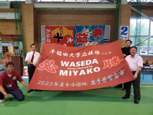 市長や応援団の部員4名が早稲田大学応援部の横断幕を持っている写真