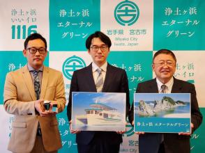バックパネルの前で、遊覧船のイラストが書かれたボードを持った男性を中央に、浄土ヶ浜の写真と浄土ヶ浜エターナルグリーンと書かれたボードを持った市長と瓶の様な物を両手で持った男性が横一列に並んでいる記念写真