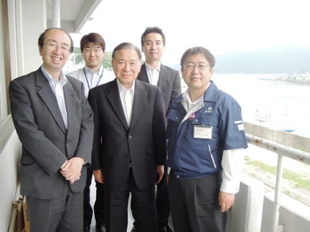 スーツを着た男性4名と市長がベランダで記念撮影している写真