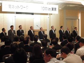 「企業ネットワークいわて2011 in 東京」の吊り看板の下、ステージ上に市長と関係者が横一列に並んでいるのを参加者席から見た写真