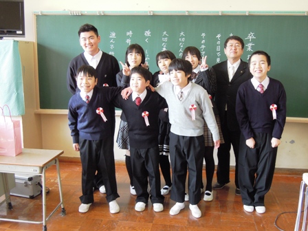黒板の前で市長と卒業生8名が2列に並び記念撮影している写真
