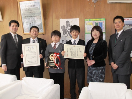 受賞した賞状と盾を手に持つ小学生達と、賞状を手に持った市長と関係者が並んでいる写真