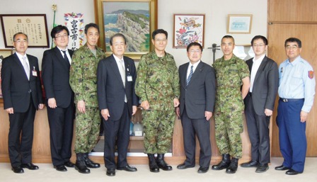 市長と迷彩服を着た自衛隊員、関係者9名が横に並んでいる写真