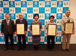 バックパネルの前で、市長と額に入った賞状を両手で持った4名の受賞者が横一列に並んでいる写真