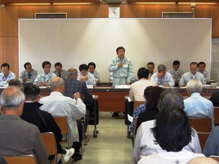 山本市長を含めた震災復興計画関係者の方々が前に座り、山本市長が自席で立って、復興計画の基本計画案を話しているのを座って聞いている参加者の方々の写真