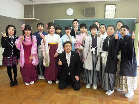 市長と卒業生する小学生達がポーズを取り、黒板の前に集合して記念撮影する写真