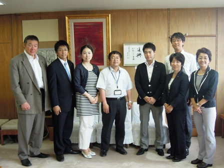 品川区議会議員男女7人と市長が横並びで記念撮影している写真
