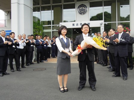 宮古市役所入口前で、花束を手渡された市長と、拍手で迎える職員の写真