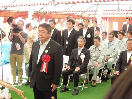 紅白幕が壁に張られたテントの下、関係者の前で安全祈願をする市長の写真