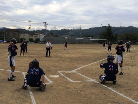 左右に1名ずつバッターとキャッチャーが構えるホームベース目掛け、マウンドに立ちボールを投げる様子の市長の写真