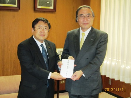 義援金の封筒を一緒に持つ市長と男性の記念写真