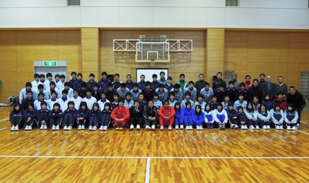 中央にバスケットゴールが設置され、その下に大勢の生徒たちが並び記念撮影している写真