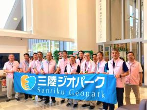 同じピンクのベストを着た10名程の関係者が三陸ジオパークの横断幕を持って並んだ集合写真