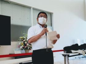 復興支援コンサートの会場で、マイクを片手に持った市長があいさつを述べている写真