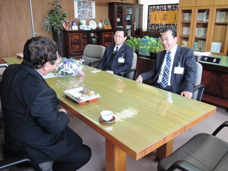 長机に向かい合わせに座る市長と2名の男性の写真