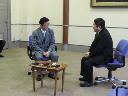 キャスターがついた青い椅子に座って話をする様子の山本市長と大阪府の松井一郎知事の写真