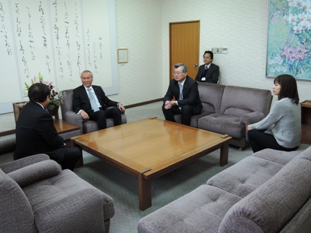 正方形の机の周りに置かれたソファーに腰かける市長と2名の男性、1名の女性の写真