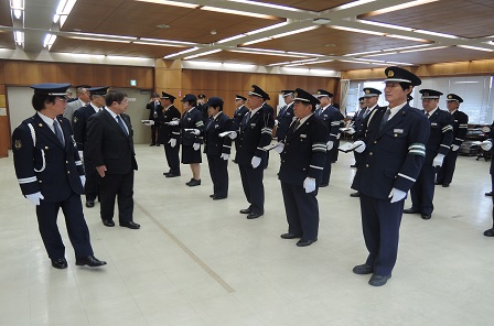 整列している制服を着た交通指導隊の方々の前を歩く市長の写真