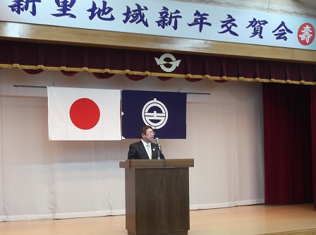 新年交賀会と書かれた横断幕があるステージで、市長が演台であいさつを述べている写真