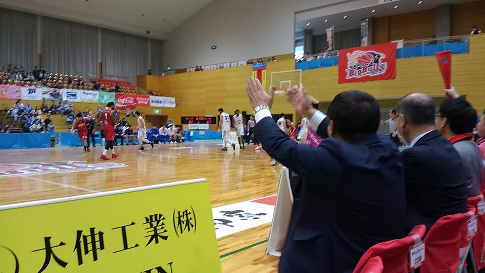 アリーナ席に座った市長が両手を上げて応援している後ろ姿の写真