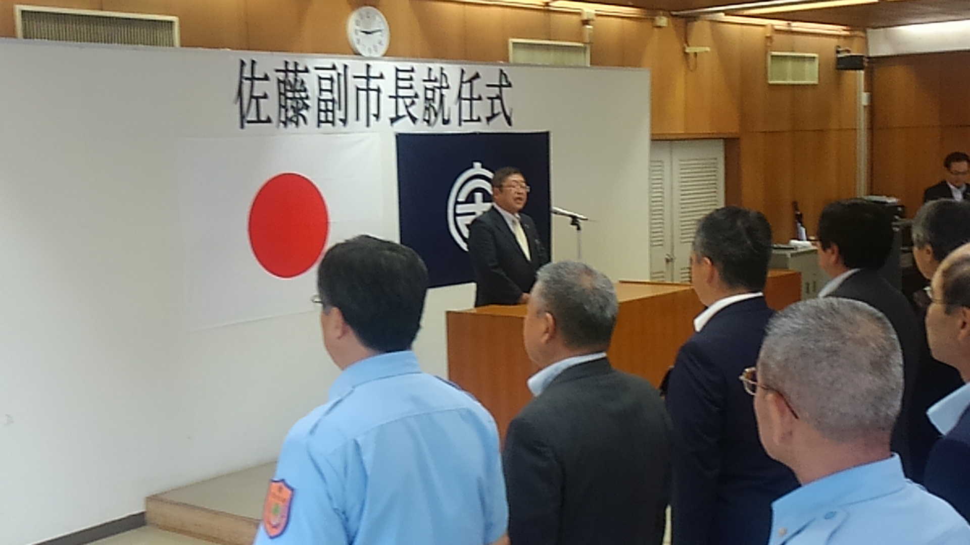 整列する職員の方々の前で、「佐藤副市長就任式」と書かれた紙と日本国旗、宮古市の市町村旗が貼られたパネルを背に立って話をする市長の写真