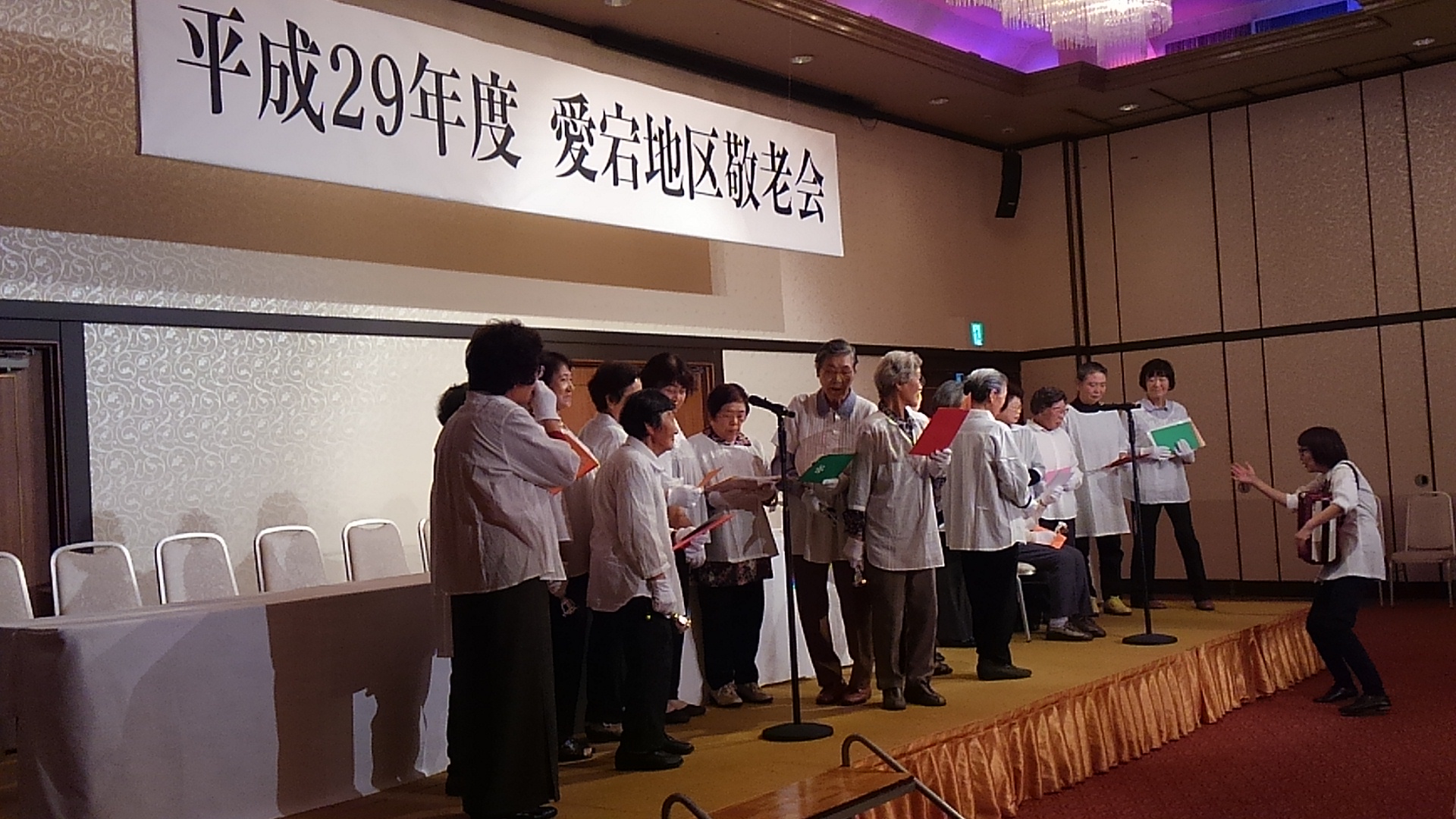 舞台上で白い衣装を着た参加者の方々が集まっている写真