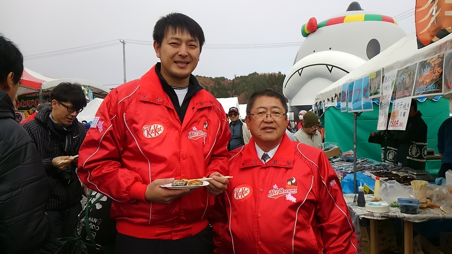 赤いジャケットを着た岩隈久志さんと市長が並んで立つ記念写真