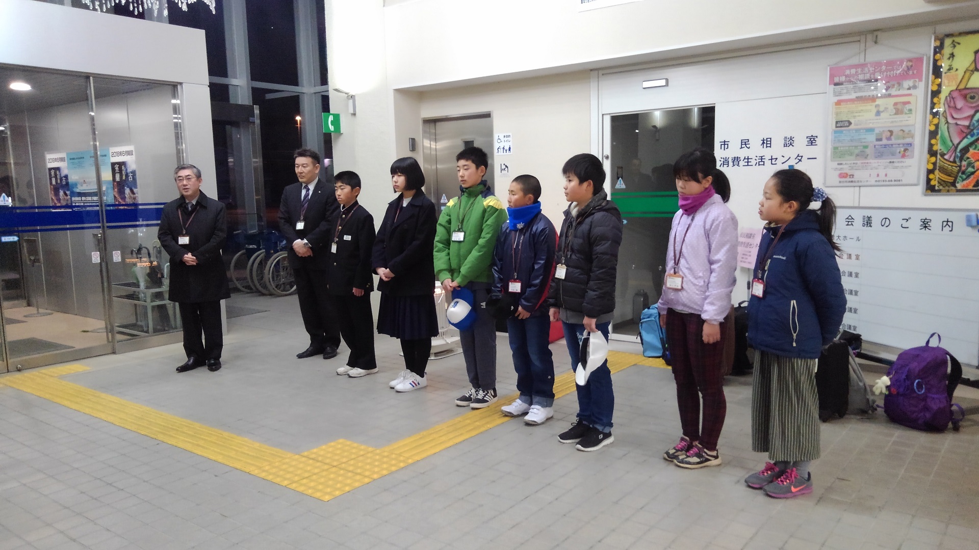 制服を着た2名の中学生、5名の小学生と男性2名が横一列に並んでいる写真