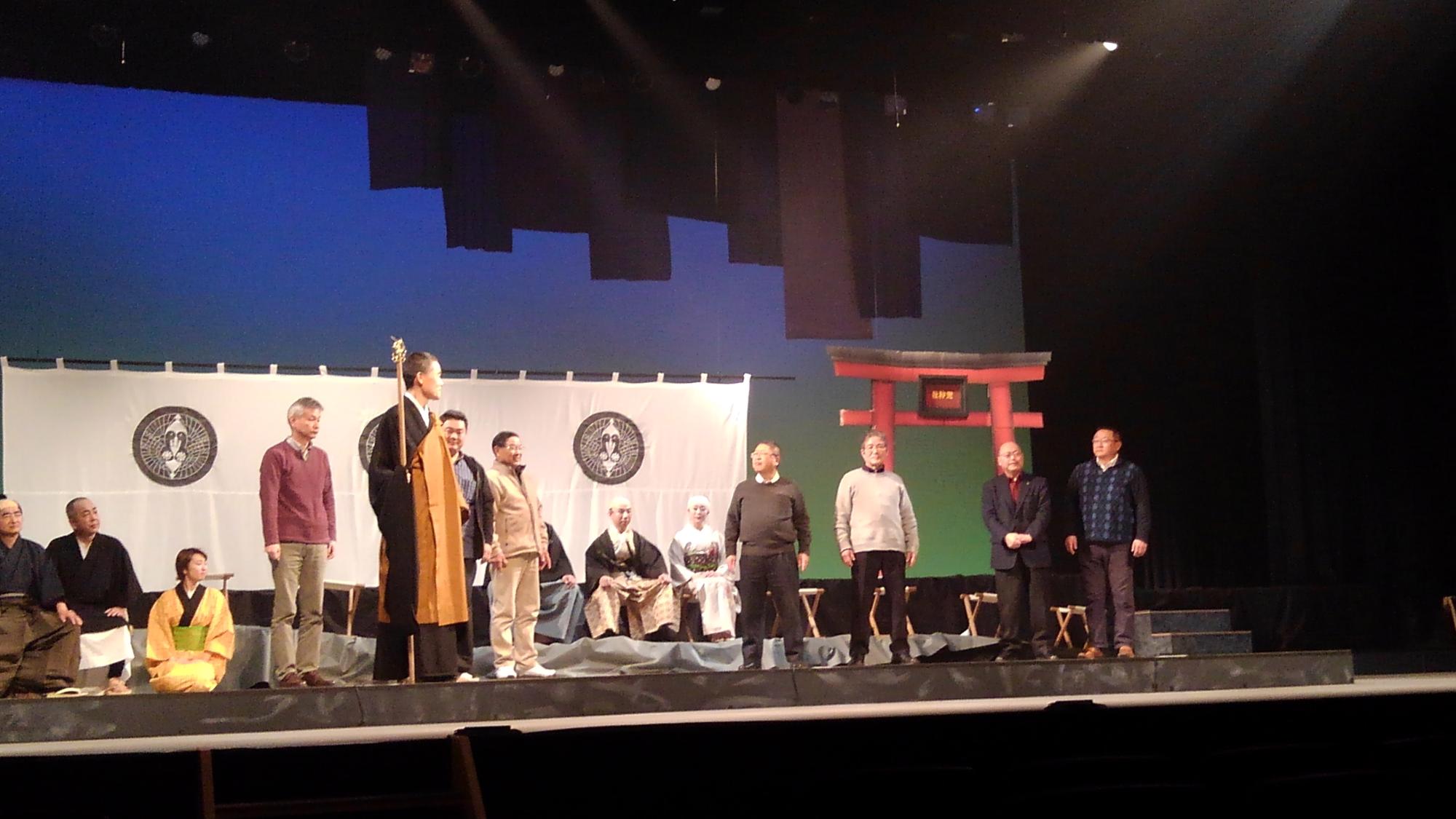 鳥居のオブジェなどが置かれた舞台で演劇する様子の演者の方々の写真