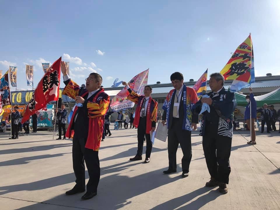 観光客のおもてなしを行った関係者や市長が、大きな大漁旗やカラータオルを降ってお見送りを行っている様子の写真