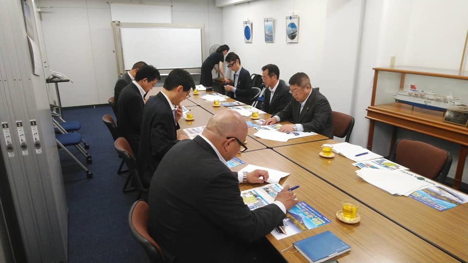 長机に向かい合うように座る市長と関係者の男性6名を写した写真