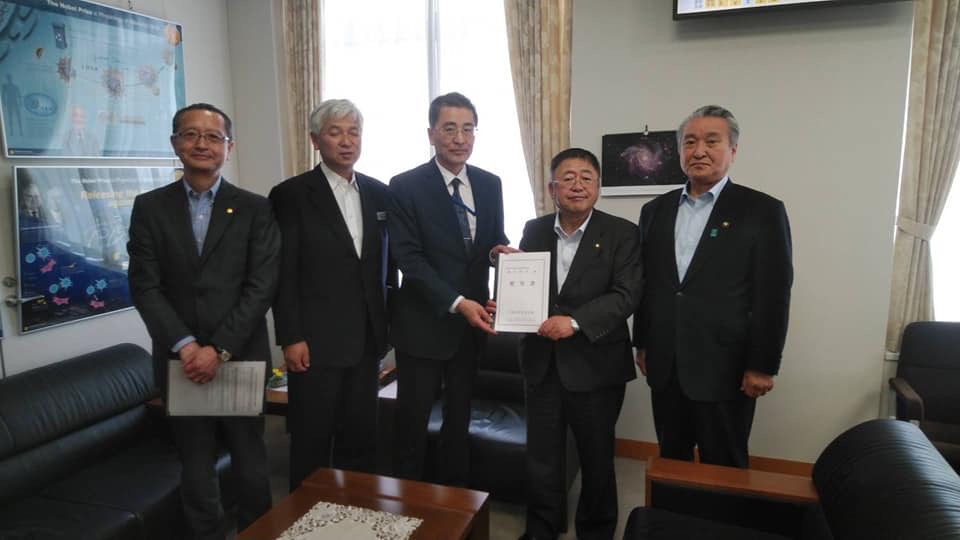 右から2番目と3番目の男性が要望書を持ち市長と関係者の男性4名が並んでいる記念写真