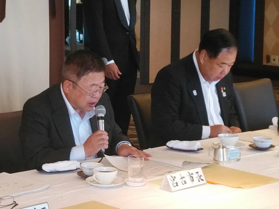 「宮古市長」と書かれたネームプレートが置かれた席につき、右手にマイクを持って話をする市長の写真
