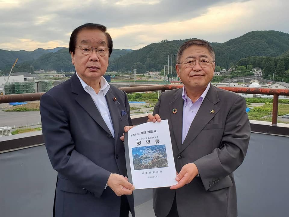 要望書を一緒に持つ市長と渡辺博道復興大臣の記念写真