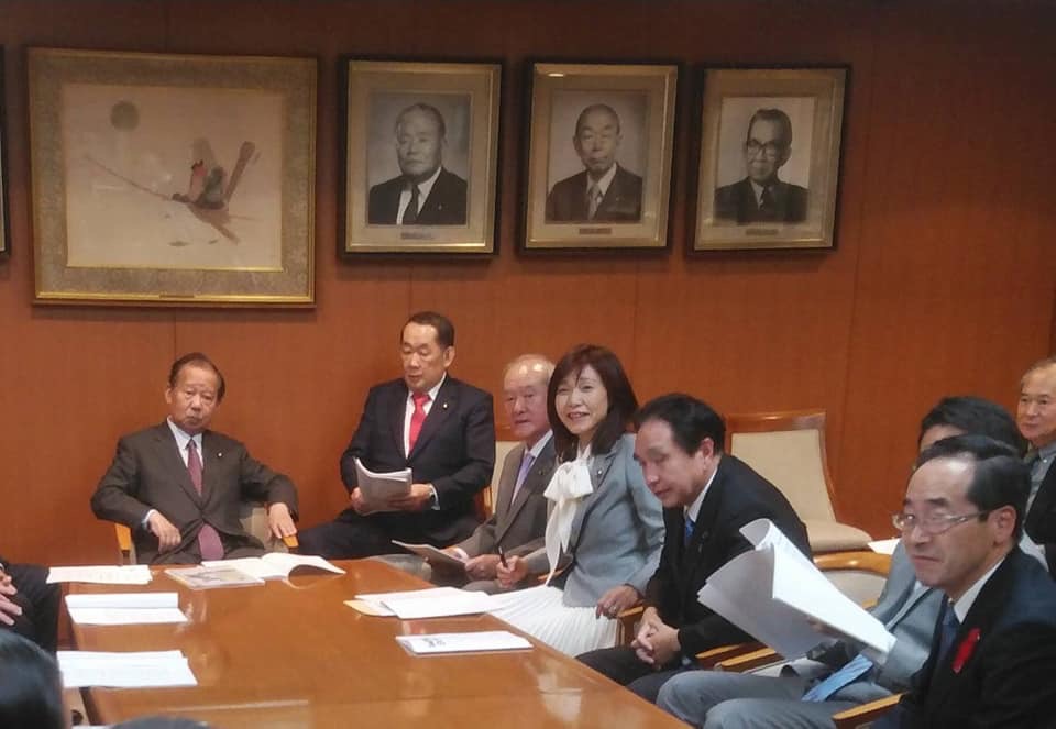 茶色いテーブルの席に着く議員の方々の写真
