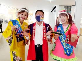 赤い法被を着た市長と岩手まるごとおもてなし隊でピンクの服に青地に黄色でマジカル河童ちゃんと書かれた襷をかけた女性と黄色の浴衣を着て、サクラ凛と書かれた襷をかけた女性と並んで撮影した写真