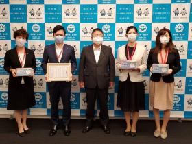 第一生命保険株式会社盛岡支社宮古営業オフィスの女性社員3人が寄贈するマスクを持ち、 男性社員が市からの感謝状を持ち、市長と並んで撮影した写真