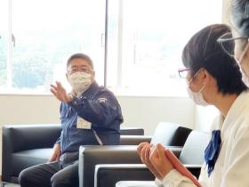 市長と高校生がソーシャルディスタンスをとって共に椅子に座り、パンフレットの記事用に市長が高校生の取材を受けている写真