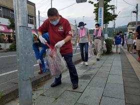 歩道でビニール袋とトングを持ちごみを拾う様子の市長と参加者の方々の写真