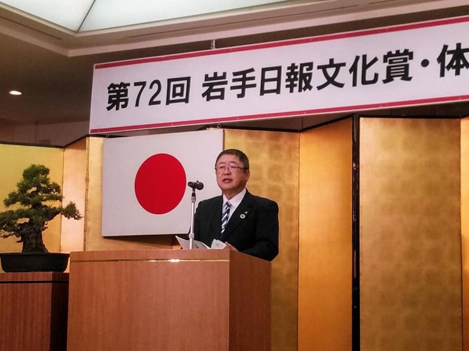 金屏風の前に置かれた演台で話をする様子の市長の写真