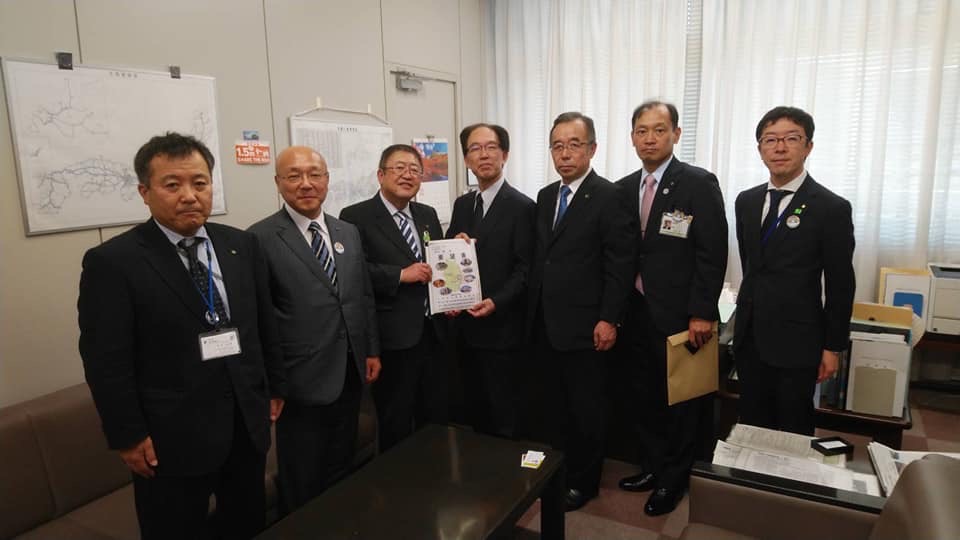 要望書を一緒に持つ市長と男性1名、関係者の男性5名が横一列に並んでいる記念写真
